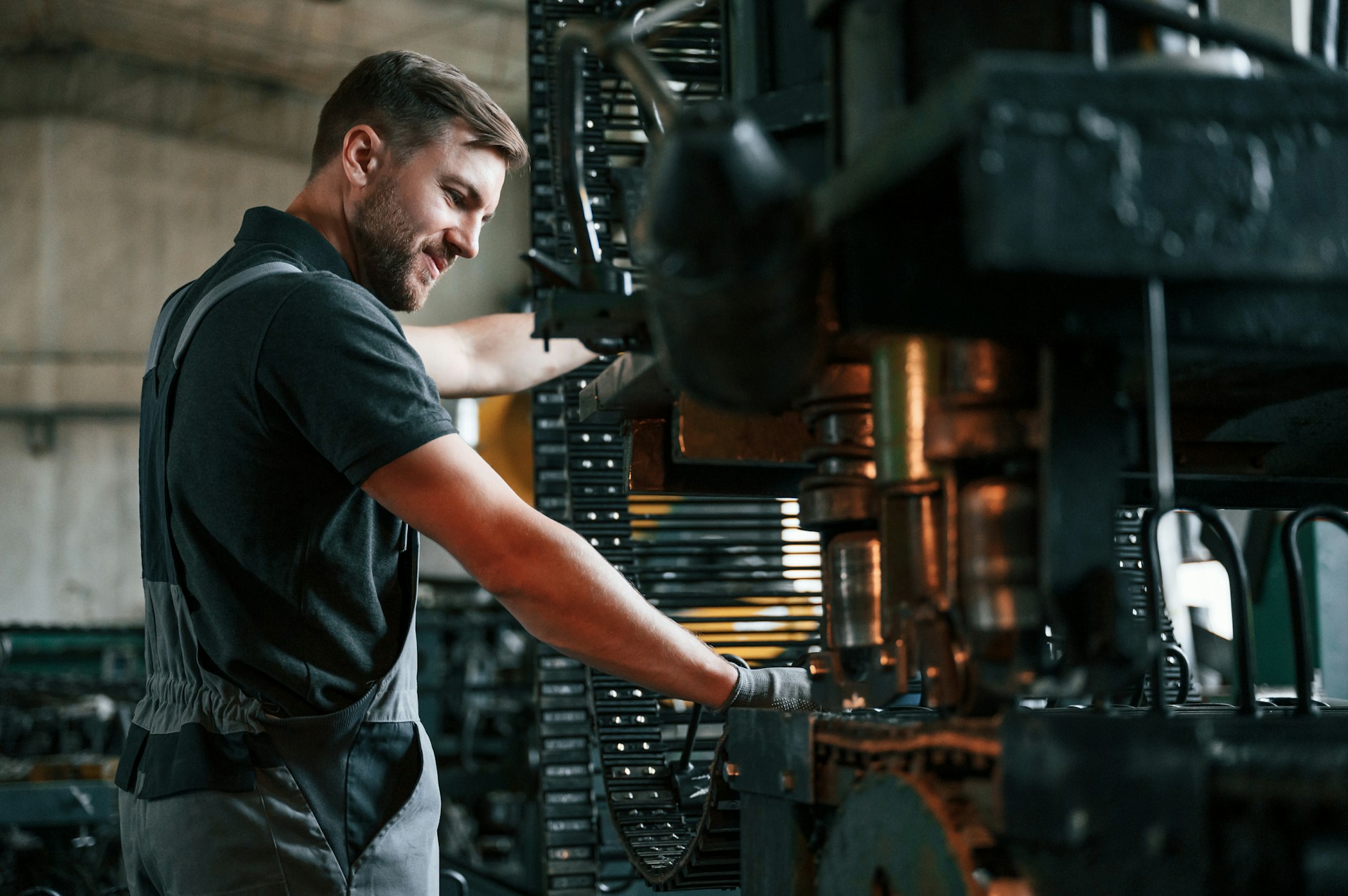 Factory worker operating industrial machinery in manufacturing facility, representing product production and environmental performance data used in EPD comparisons