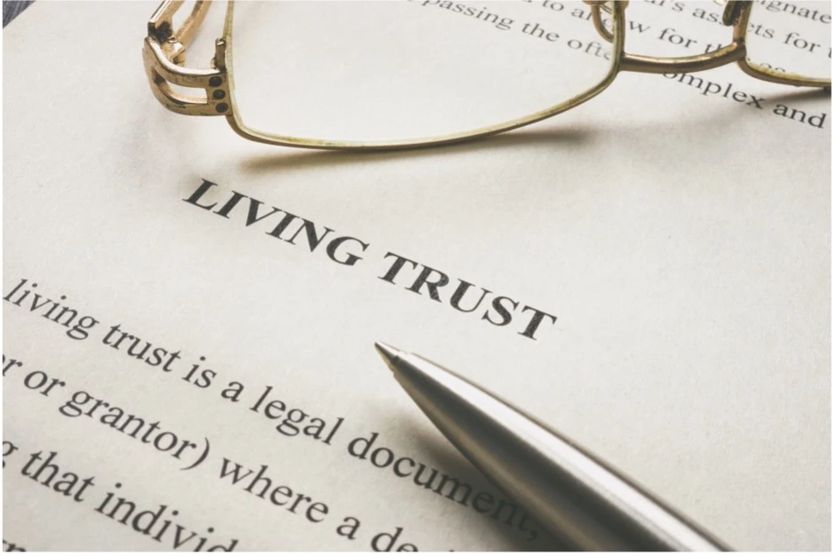 Close-up of a legal document titled “Living Trust” with a pen and reading glasses