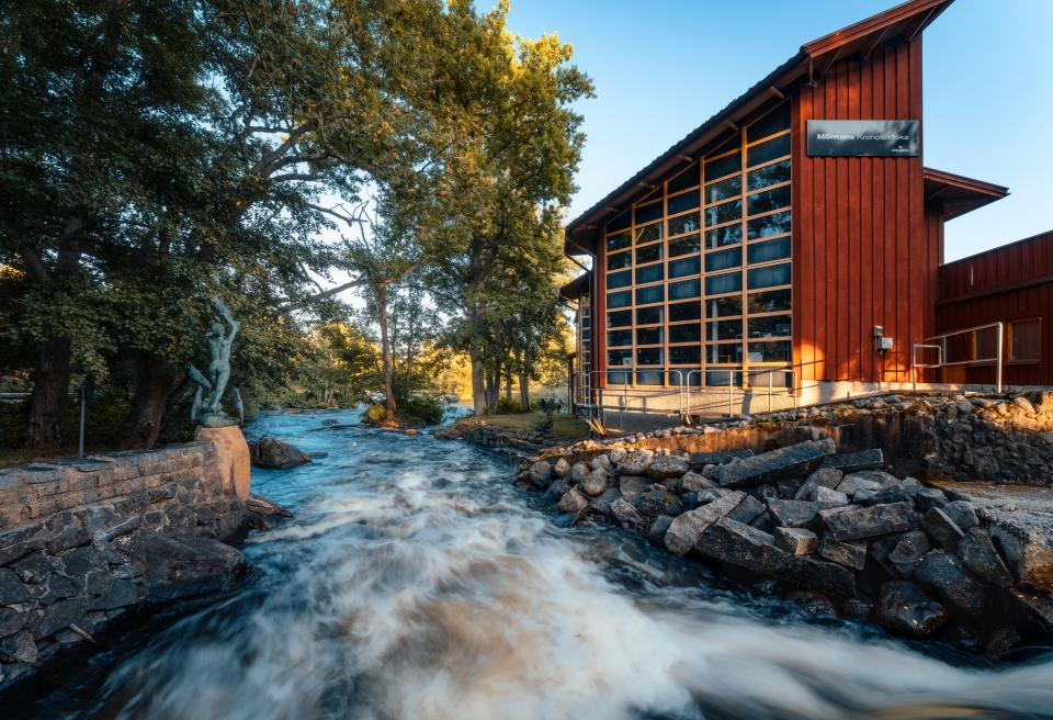 Modern riverside building beside fast-flowing water and woodland surroundings, symbolising complexity, movement and changing landscapes, suitable for themes relating to SDLT, property law, regulation or navigating uncertainty.