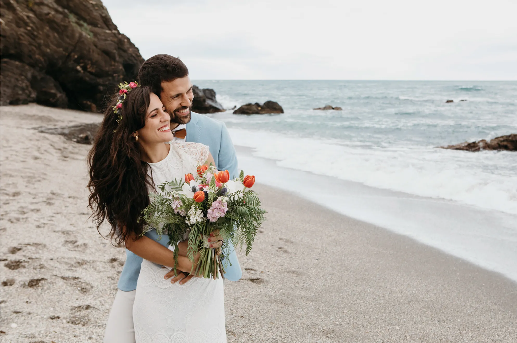 couple on the beach in their wedding outfits