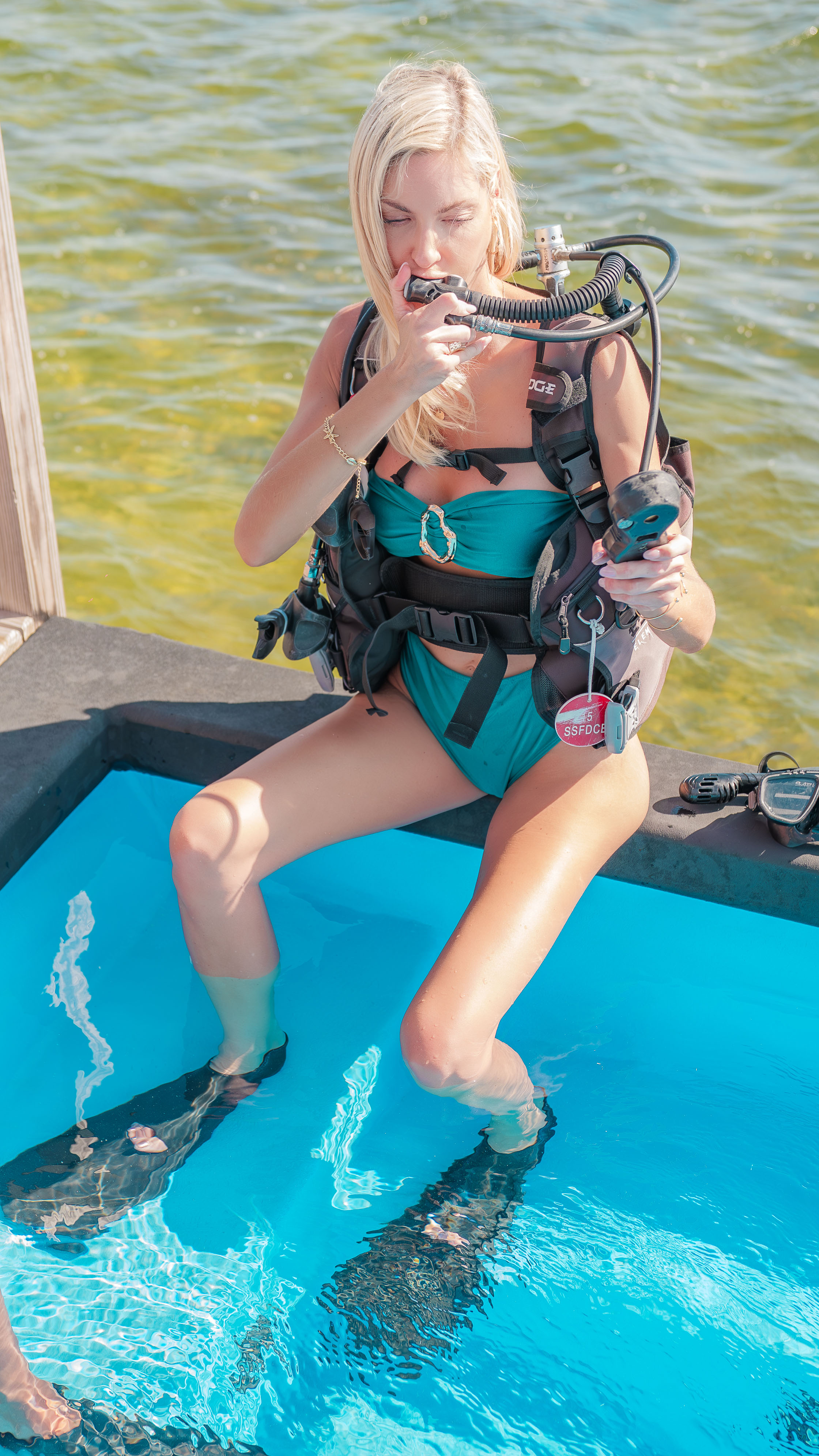 Woman practicing breathing through scuba regulator in water