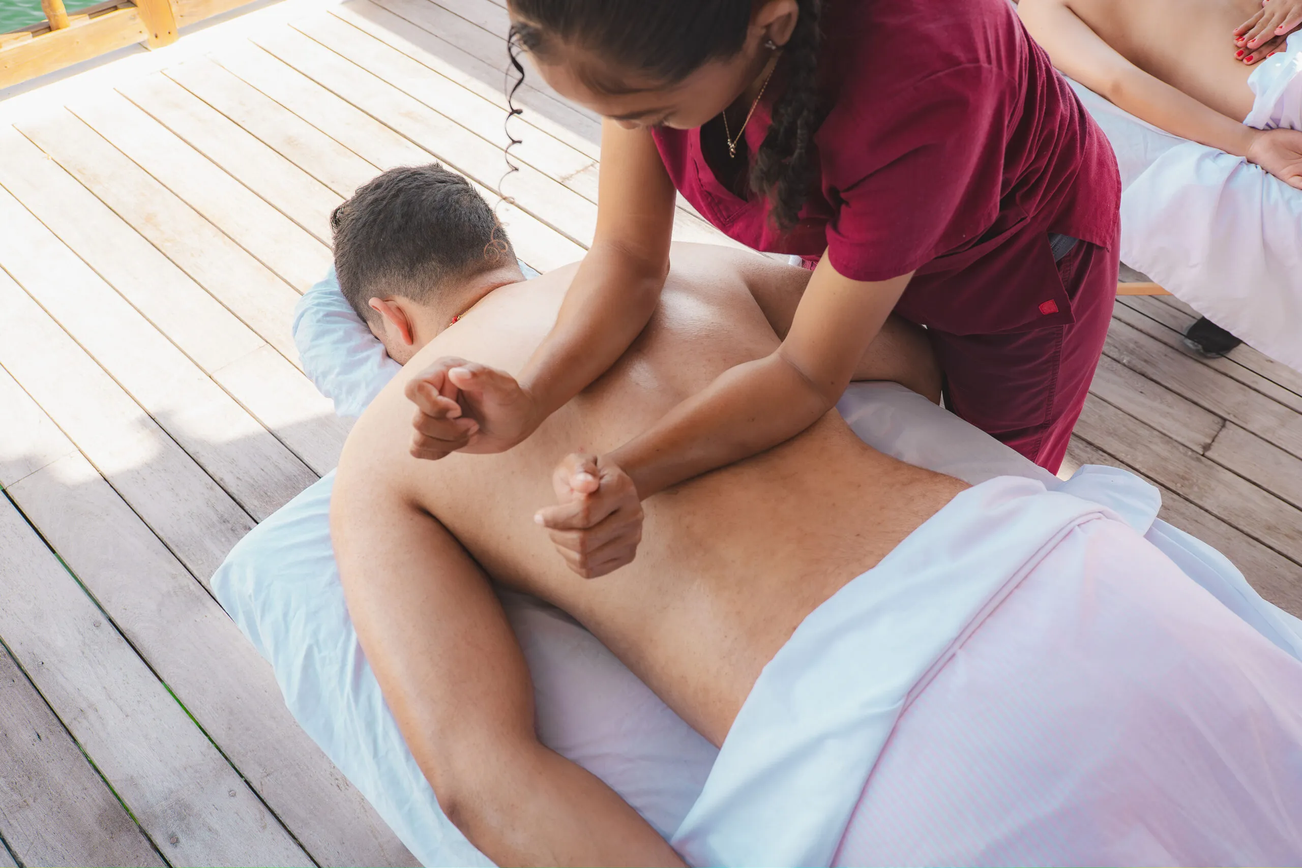 Outdoor massage treatment at seaside spa deck.