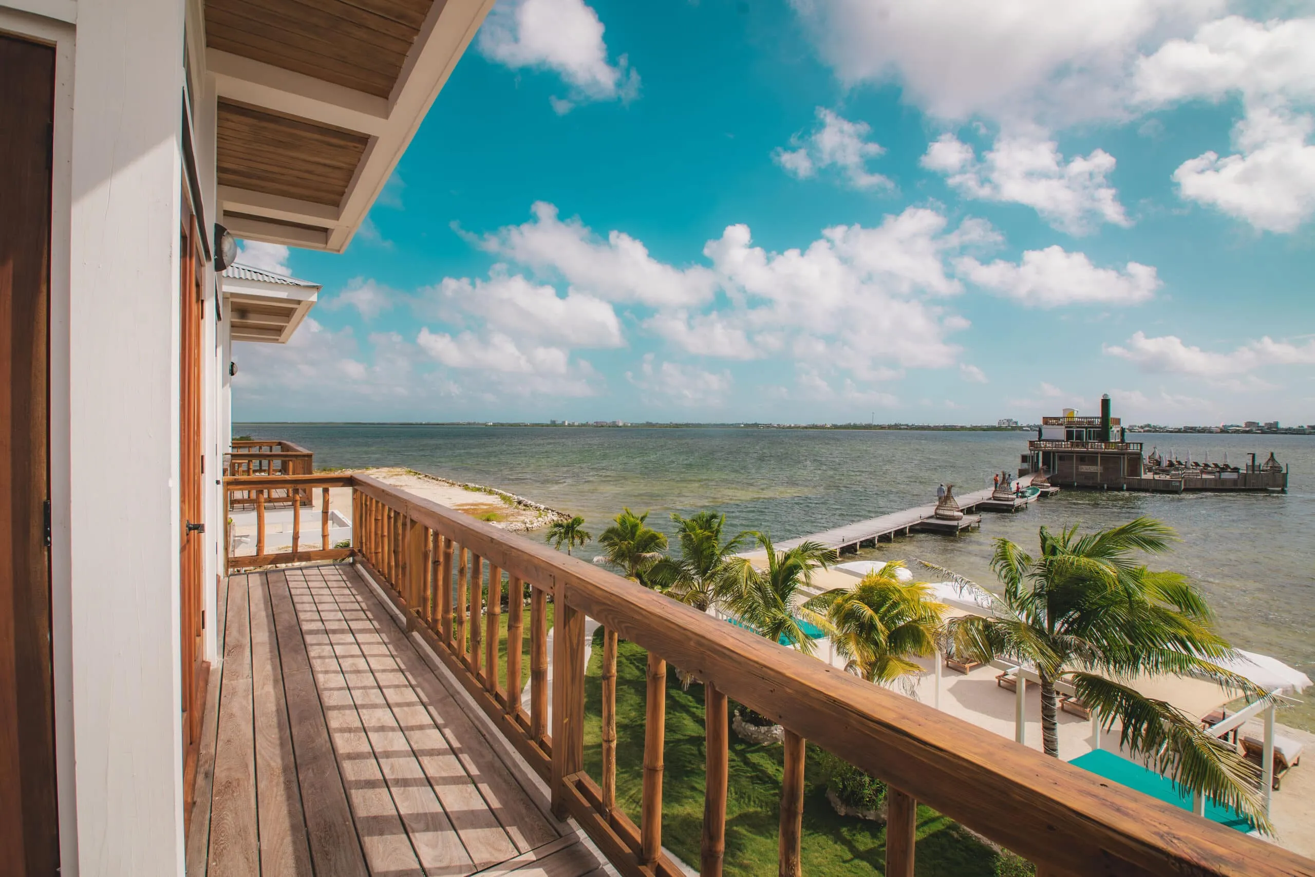 Oceanfront balcony with panoramic water and pier views.