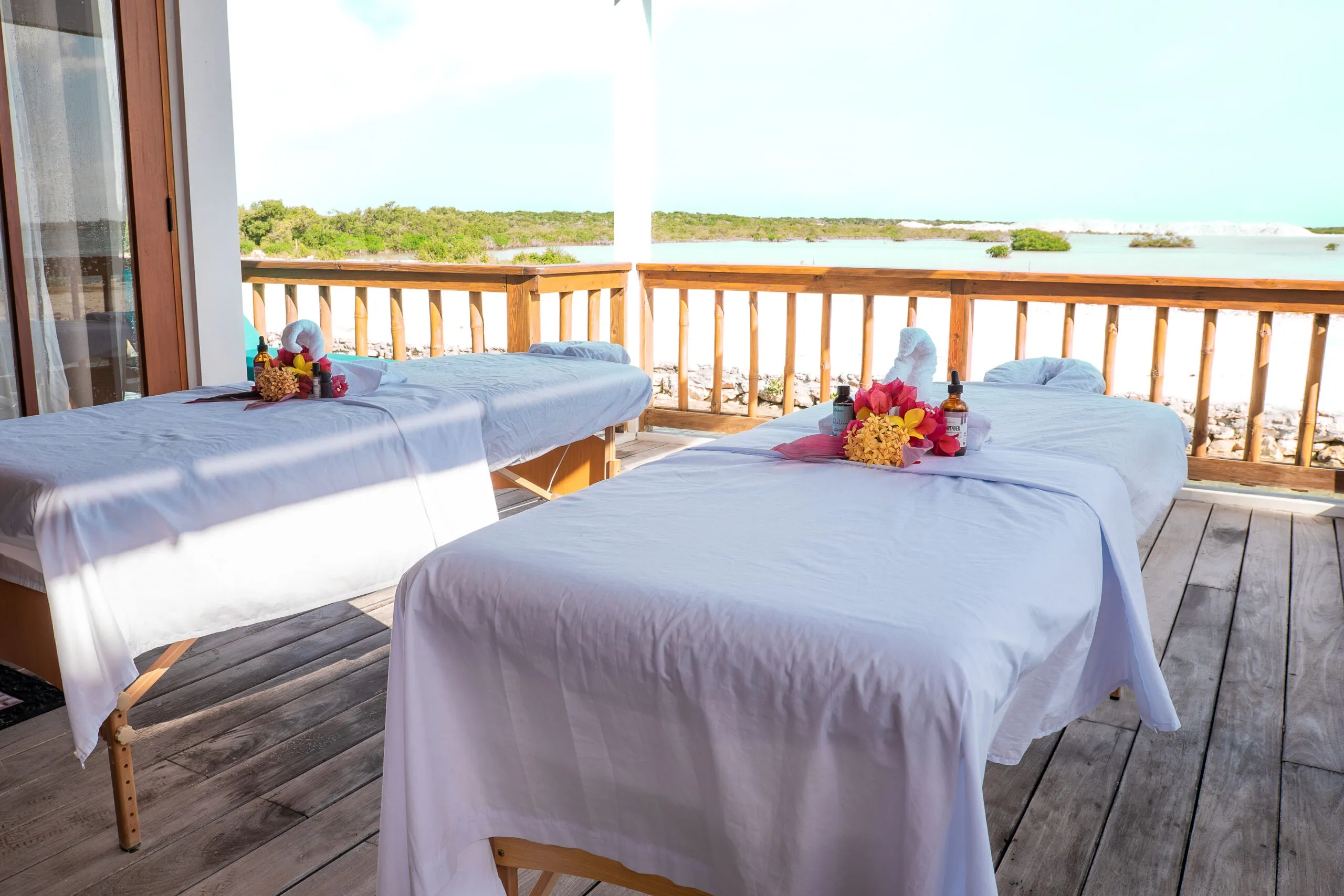 Open-air spa tables with tranquil lagoon views.