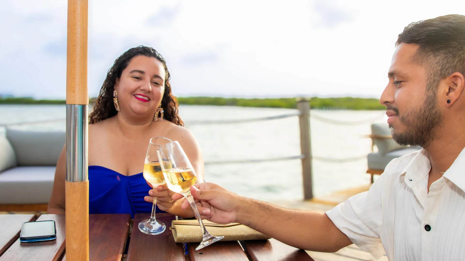 Couple toasting wine with waterfront views.