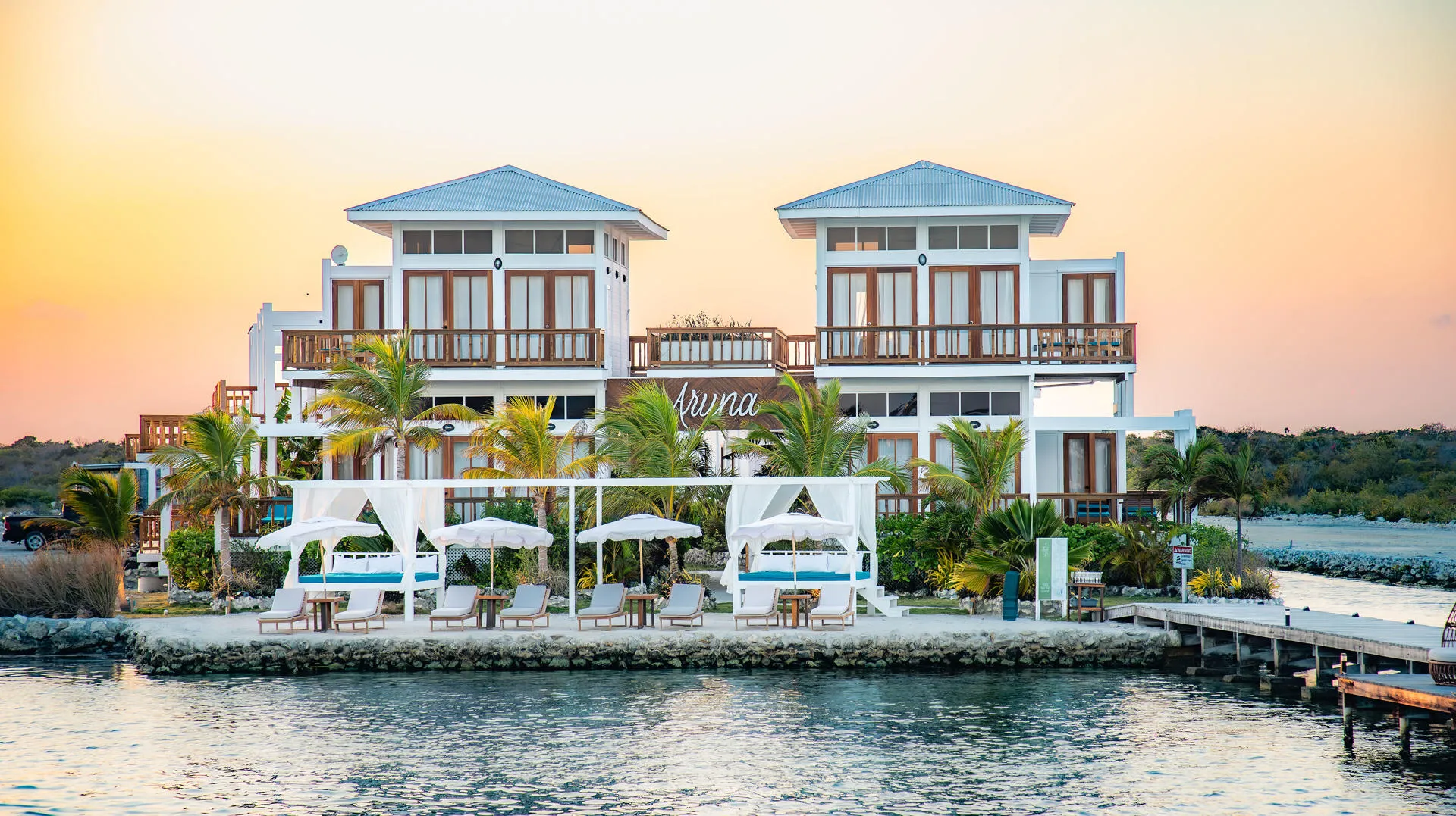 Aruna Resort beachfront villas and cabanas at sunset.
