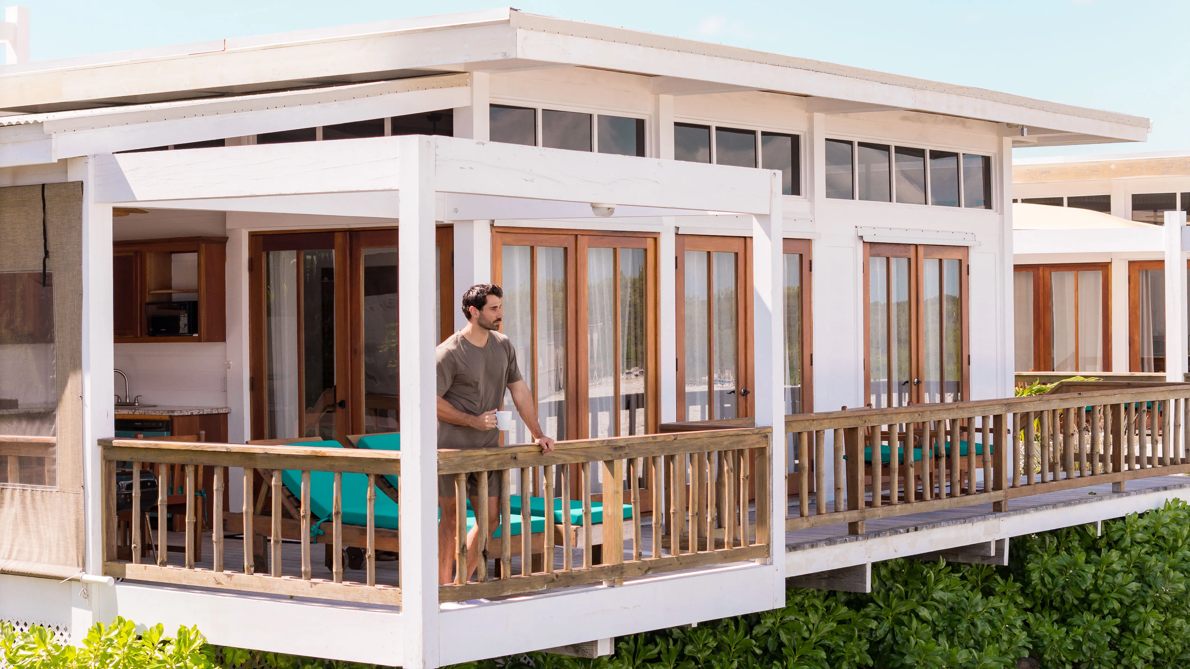 Guest enjoying morning coffee on private balcony at Aruna Resort Belize