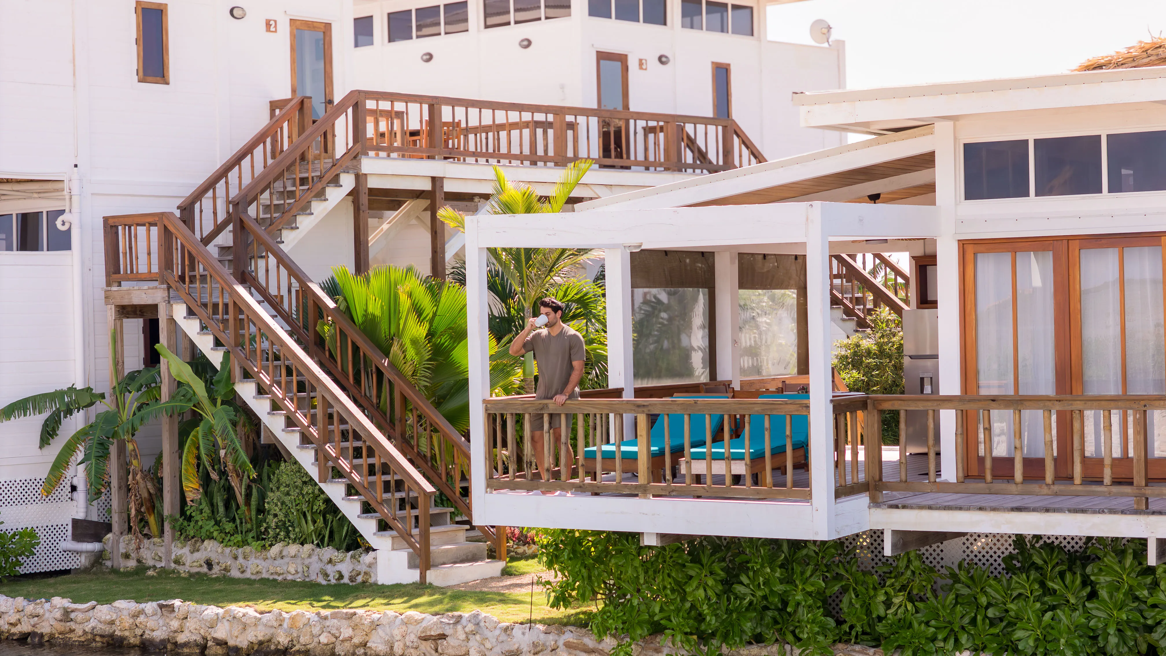 Guest relaxing on villa terrace with tropical garden at Aruna Resort