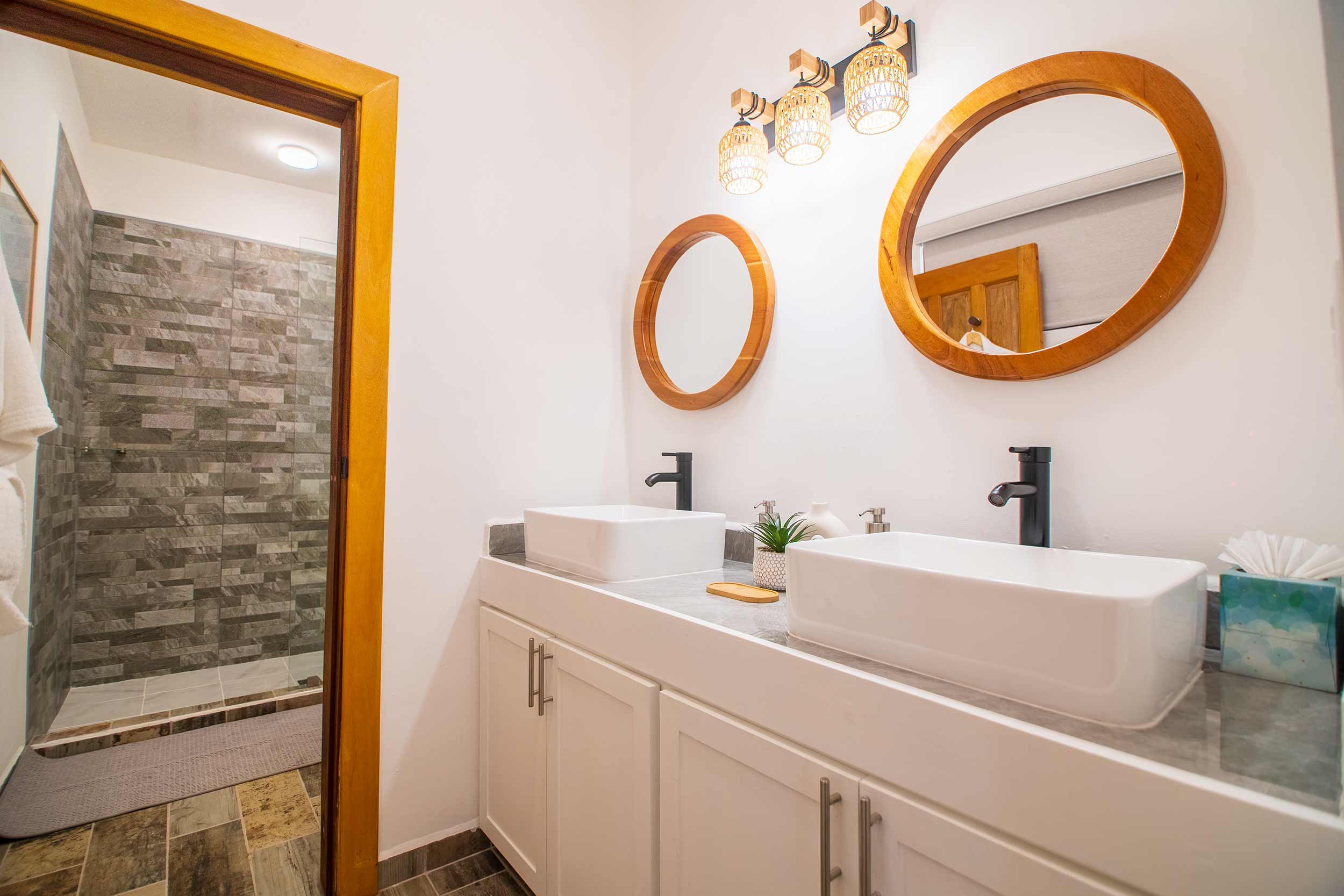 Comfortable armchair beside sliding glass doors leading to a sunlit balcony with tropical plants.
