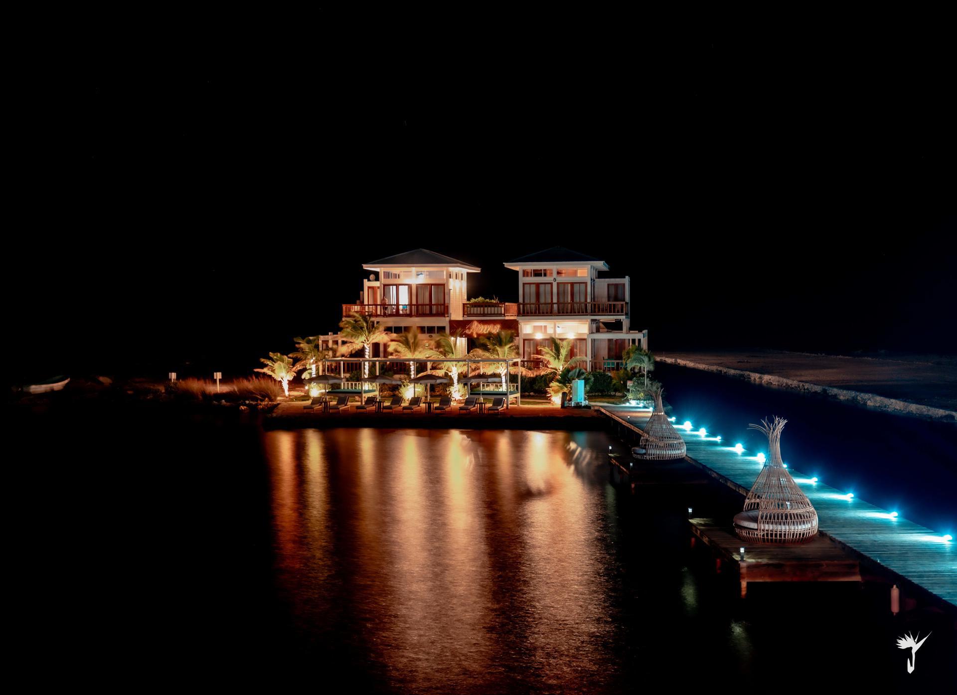Aruna Resort and Villas glowing over the water on a festive night in Belize