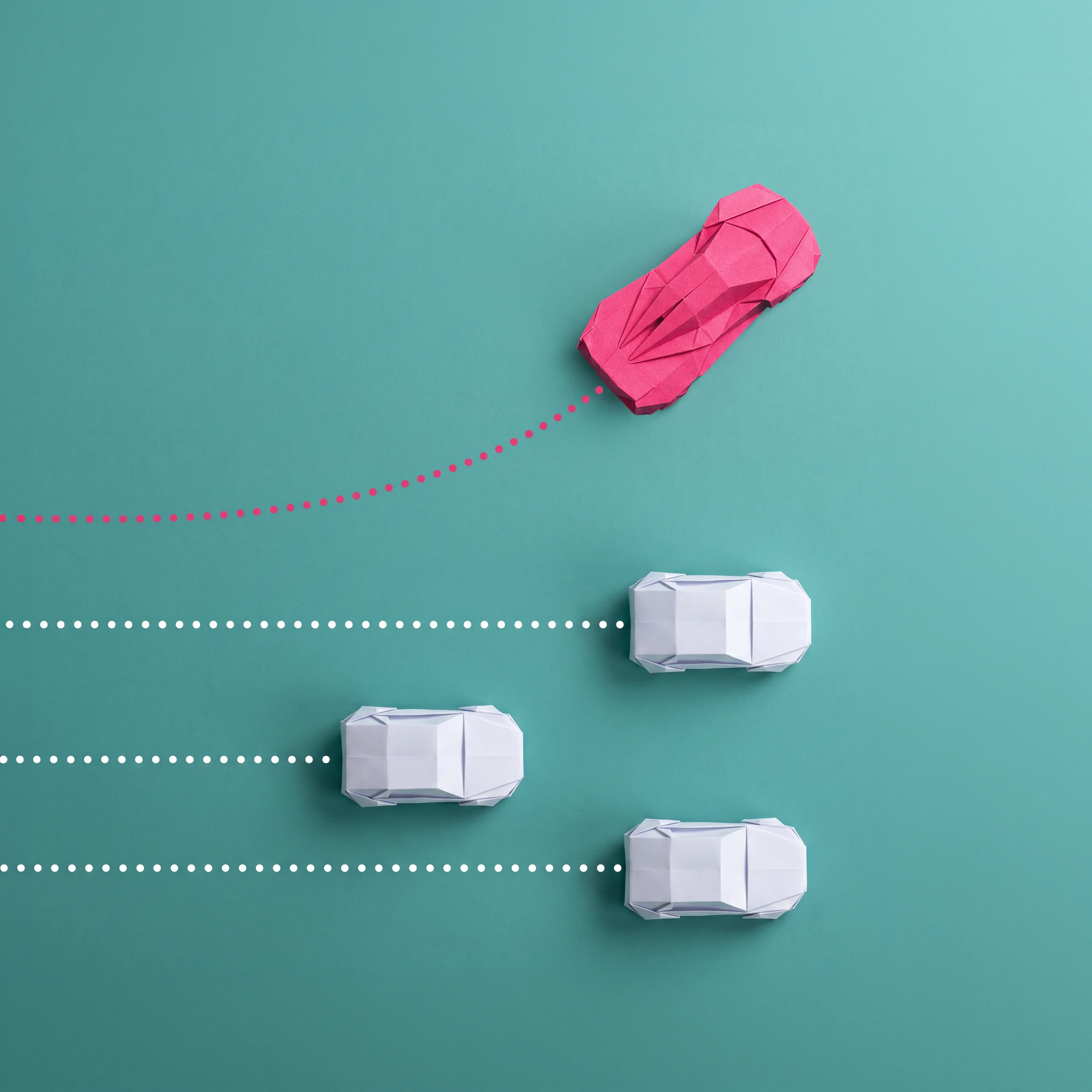 One red model car made of paper veering to the left with a red dotted trajectory line, while three white paper model cars follow straight white dotted lines on a teal background.