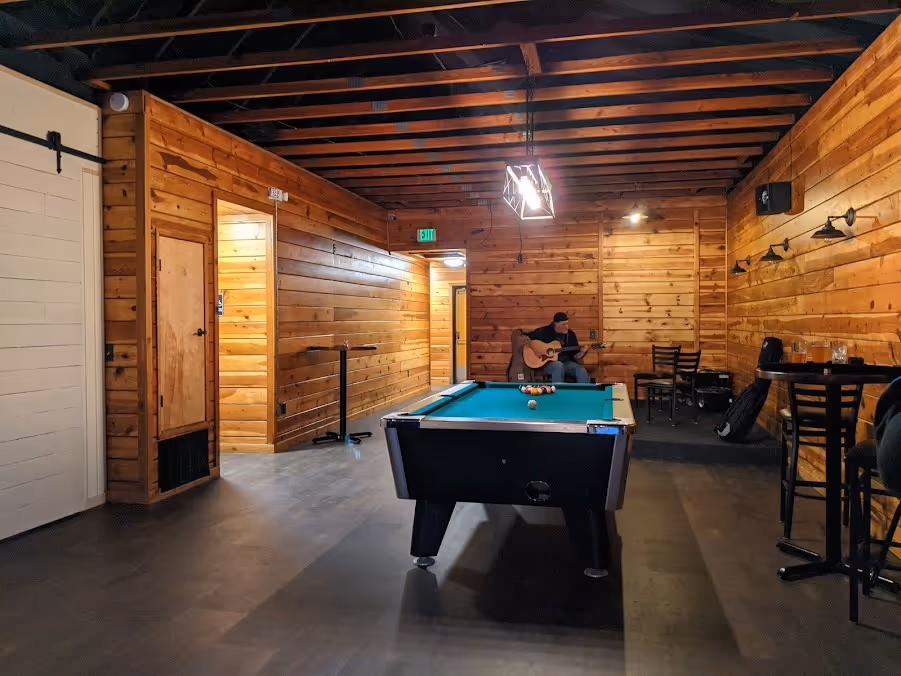 A pool table set in a room with wooden walls, creating a warm and inviting atmosphere for games and gatherings.