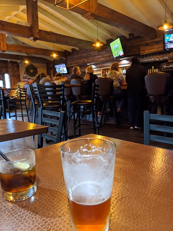 A glass of beer on a table in a bar.