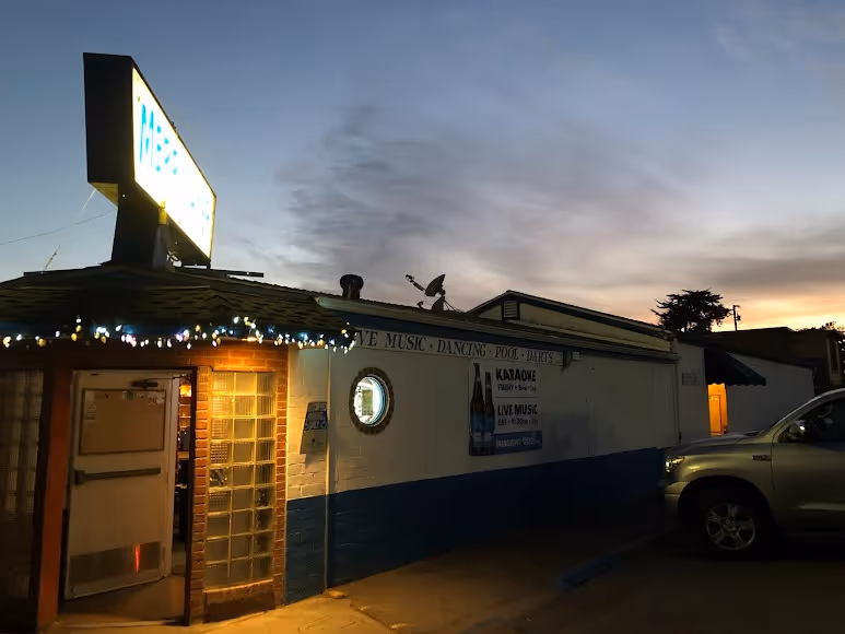 A restaurant with a "dinner" sign and a car parked in front, indicating a welcoming dining atmosphere.