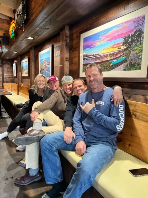 A group of people sitting on a bench in a restaurant.