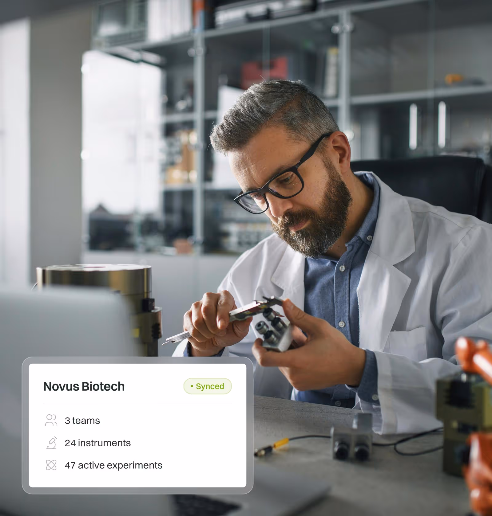 Scientist in a lab coat examining a scientific instrument with a digital overlay showing the synced data platform for an enterprise team.