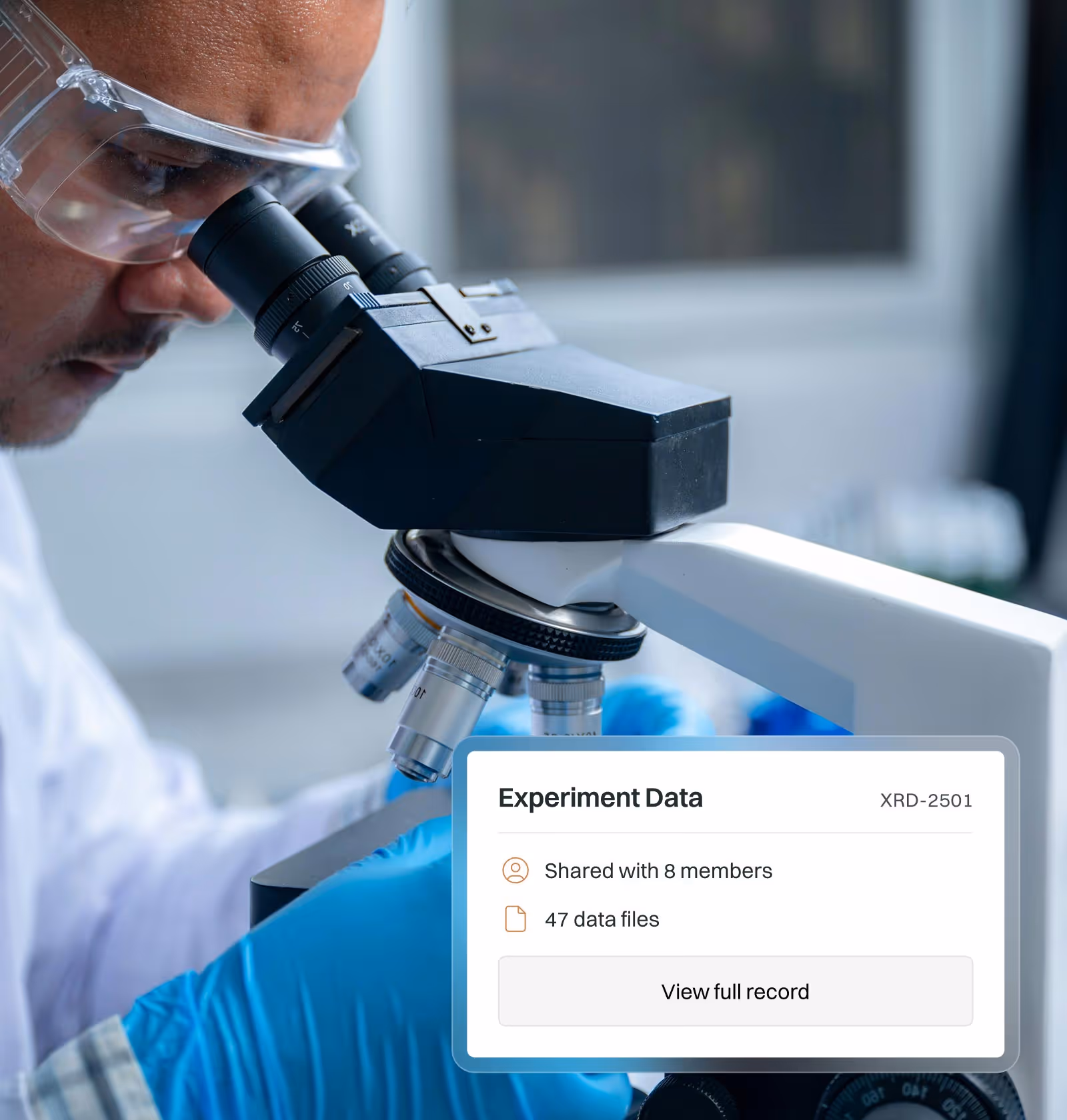 Scientist wearing safety goggles and blue gloves examining a sample under a microscope with an overlay showing experiment data shared across an academic research team.
