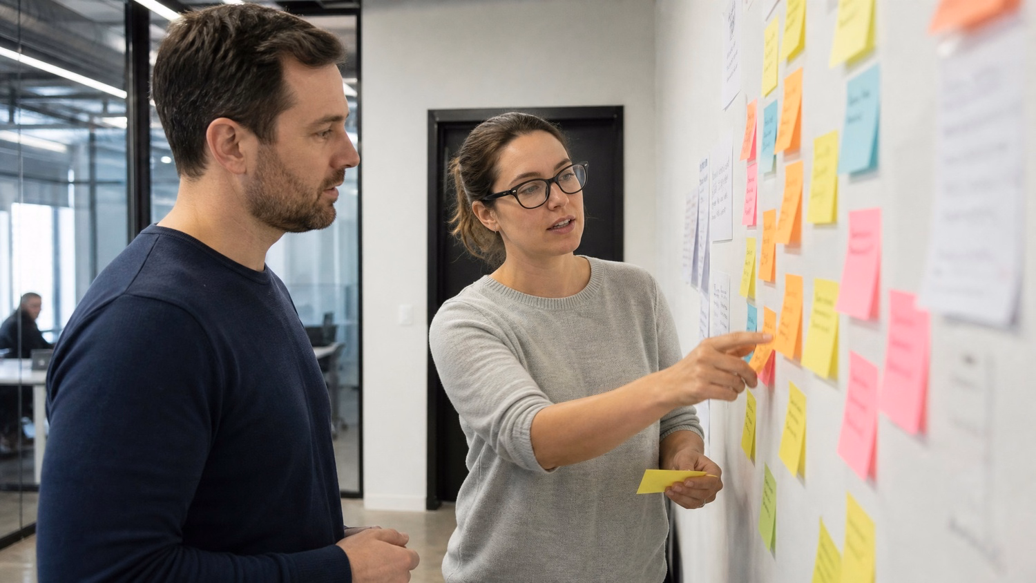 STICKY NOTE WALL An IT professional  two people standing at a wall covered wi