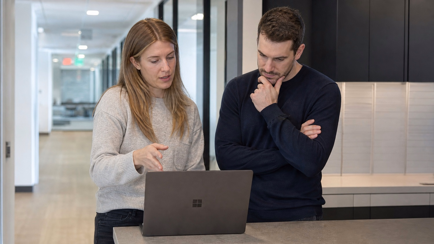 INFORMAL HUDDLE An IT professional  two people standing and talking near a ki