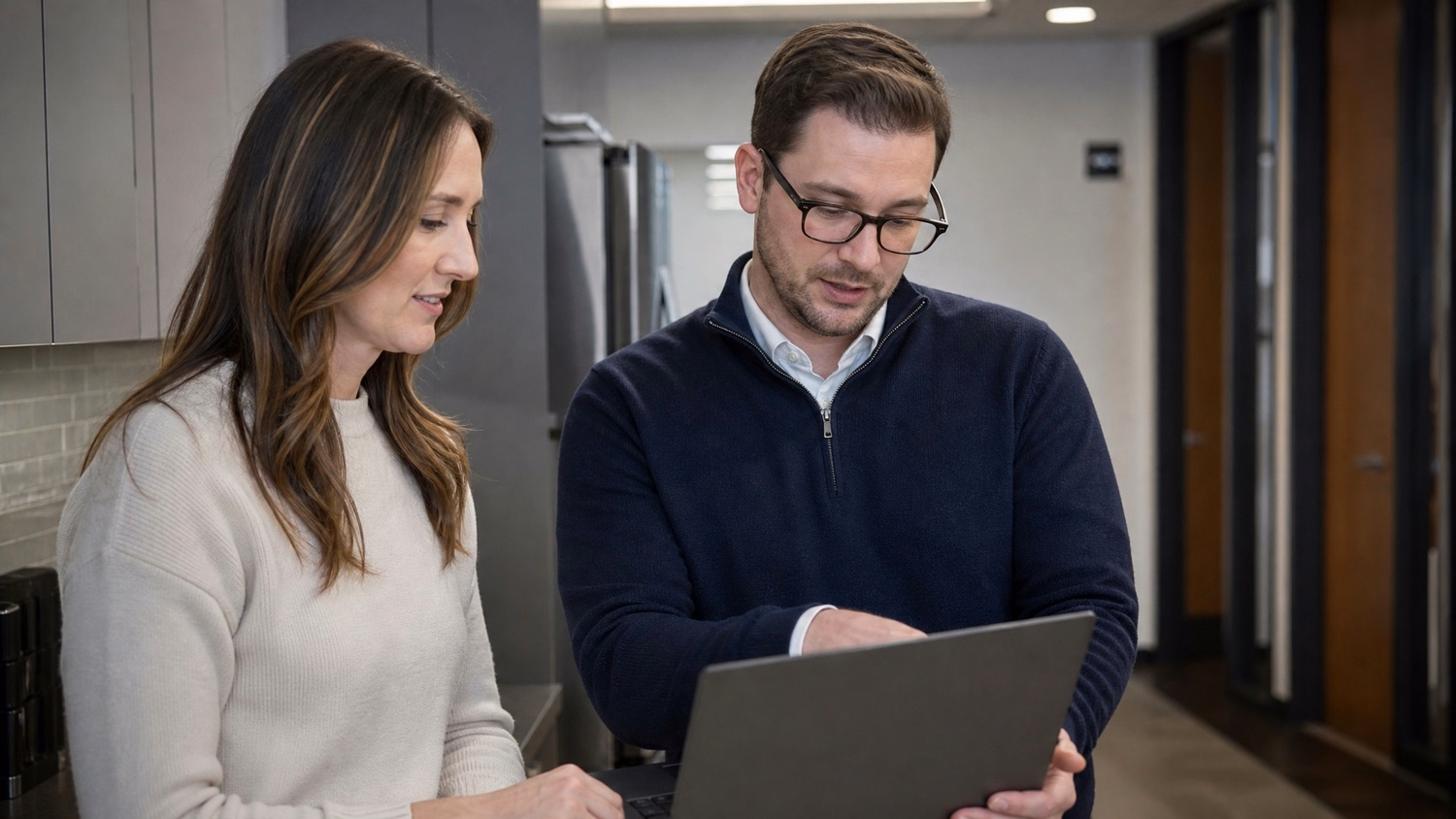 INFORMAL HUDDLE An IT professional two people standing and talking near a ki
