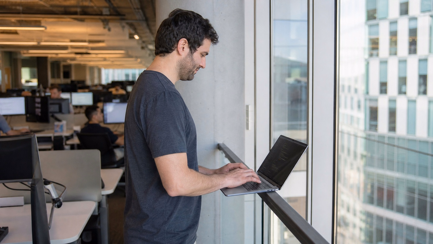 Man coding on laptop at balcony rail 45 chars