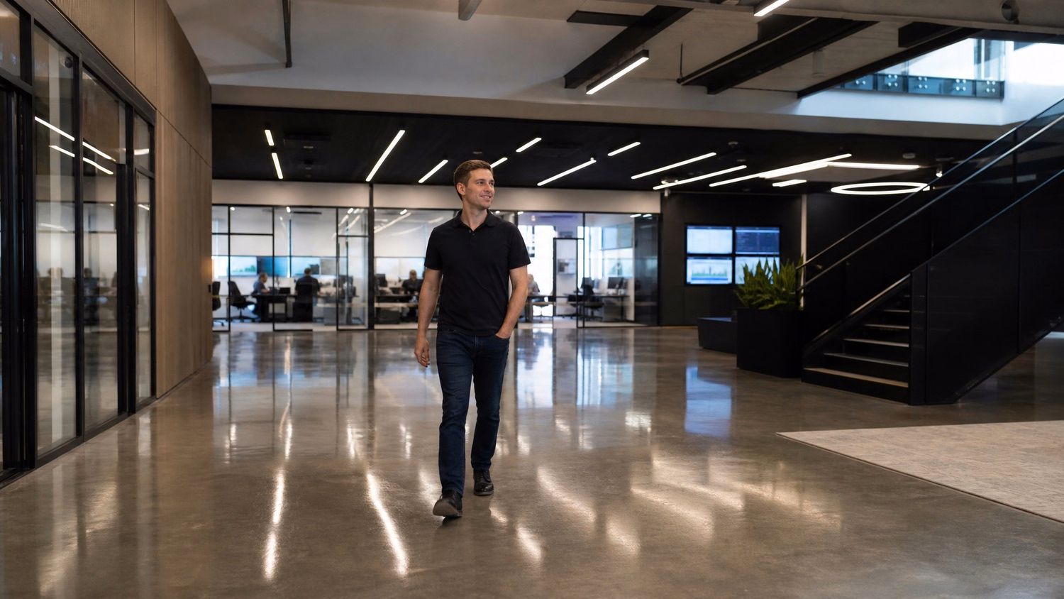 Lone IT worker crosses expansive, modern office lobby 60 chars