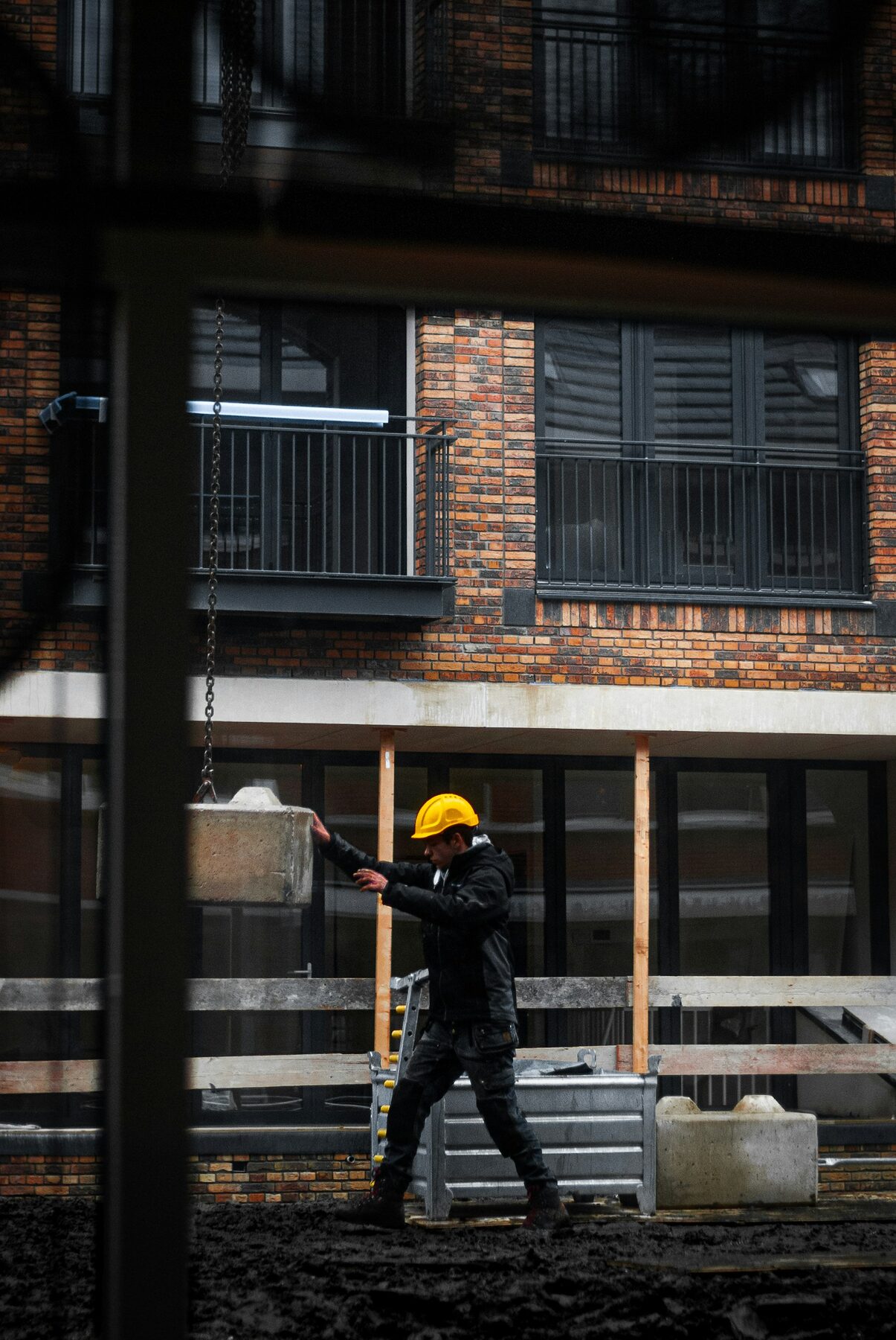 Construction worker in a yellow safety helmet working on a brick-built site