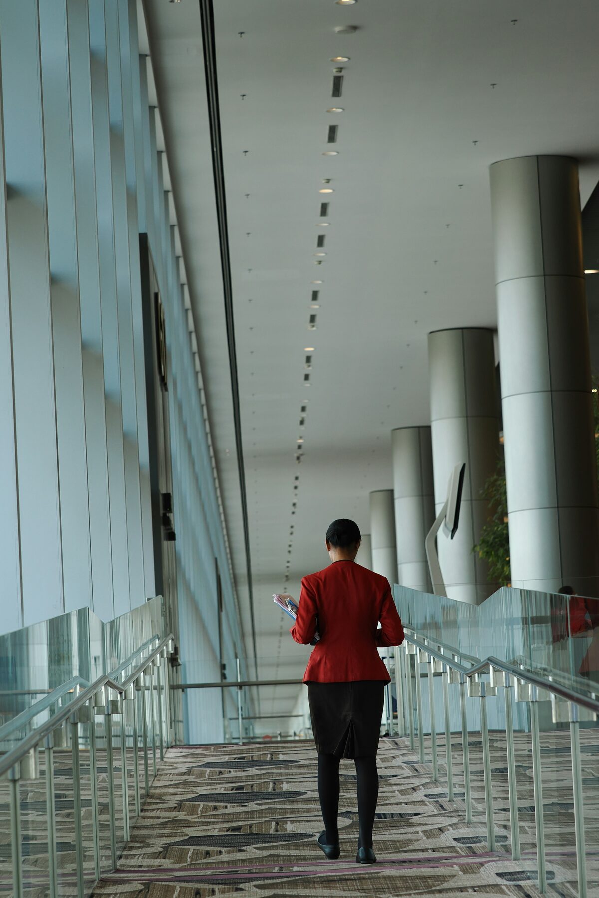 Services staff member walking a concourse with papers in hand