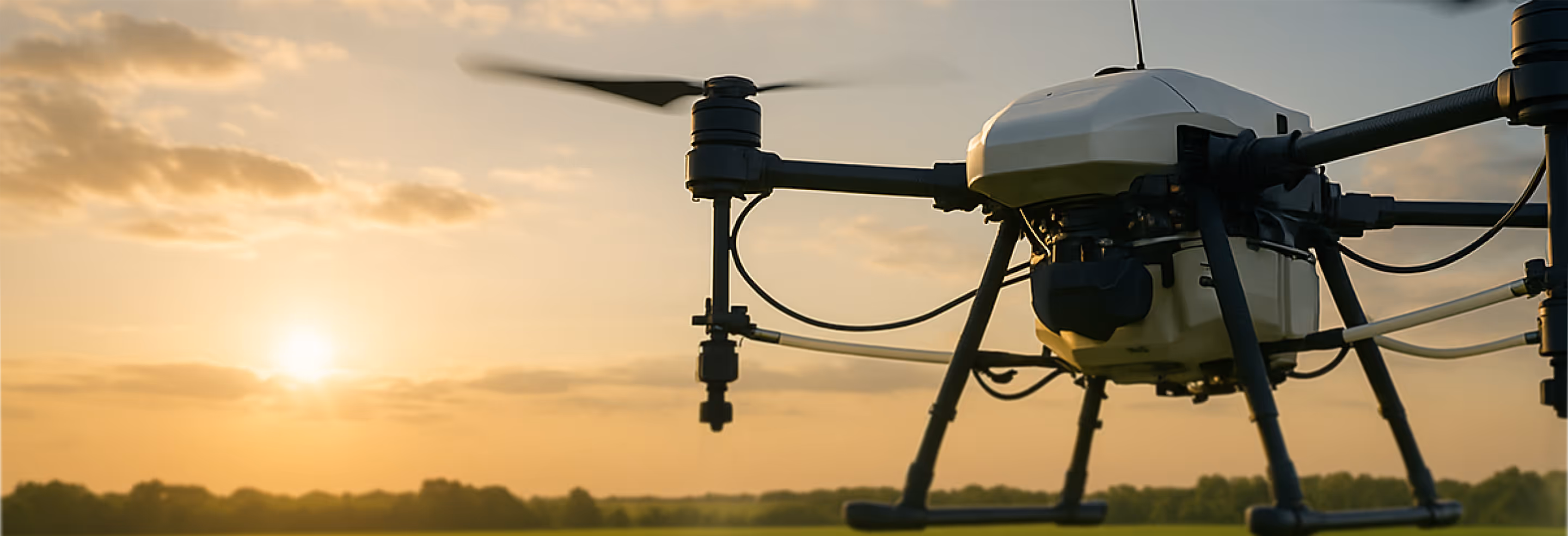 Close-up of a drone flying outdoors with a sunset and fields in the background.