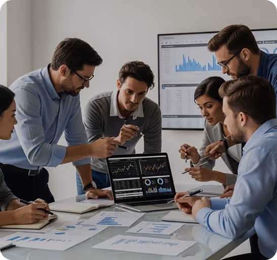 A group of six professionals engaged in a discussion around a laptop displaying financial graphs and charts, with documents and notes on the table in a modern office setting.