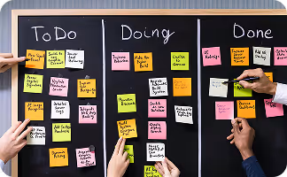 People organizing tasks on sticky notes across to-do, doing, and done boards for project management.