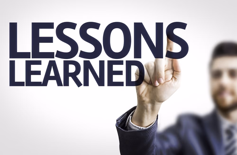 Business man pointing to transparent board with text Lessons Learned