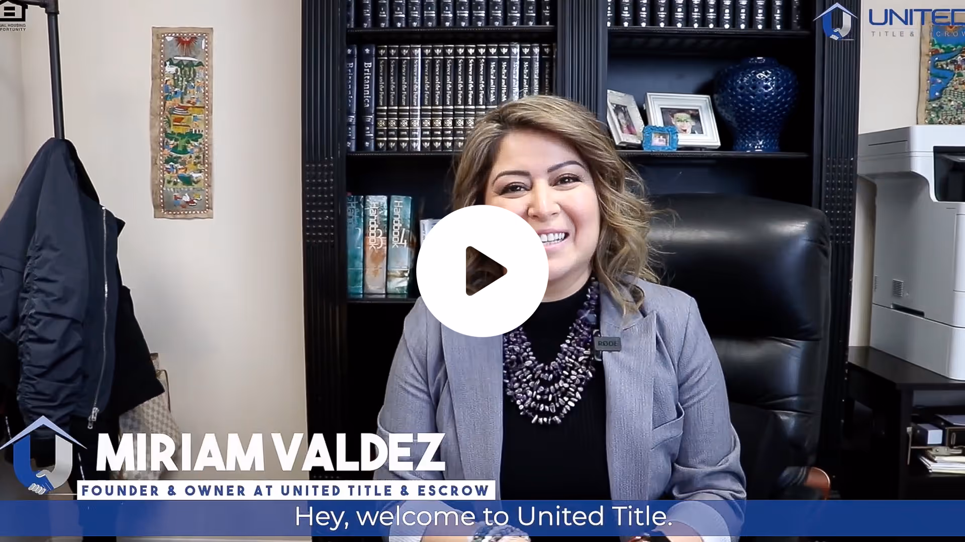 Smiling woman named Miriam Valdez, founder of United Title & Escrow, seated in an office with bookshelves and office equipment behind her.