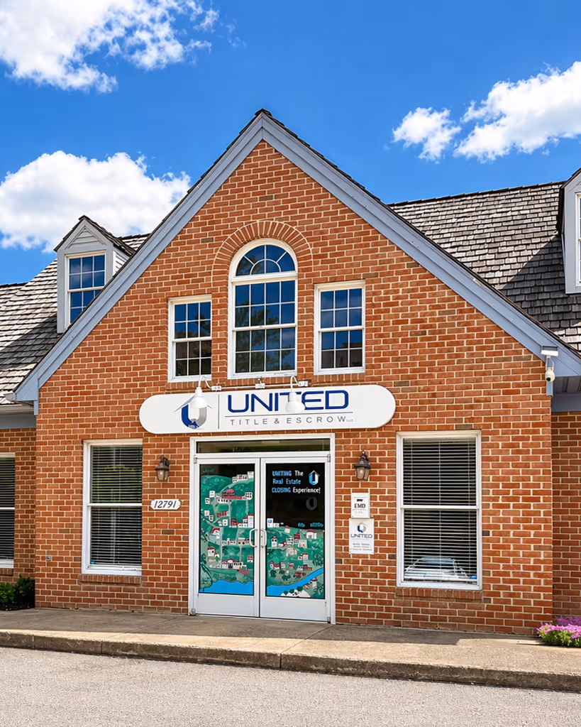 Brick office building with a sign reading United Title & Escrow above double glass doors