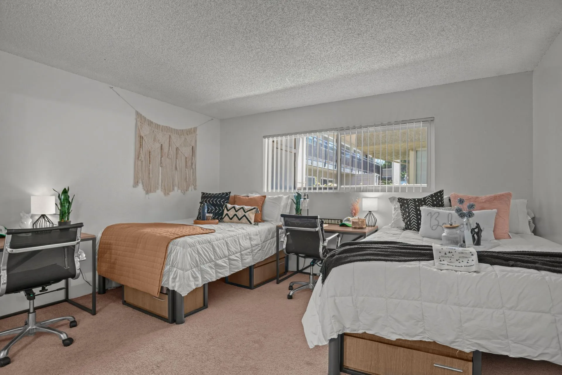 bedroom with beds and desks with chairs