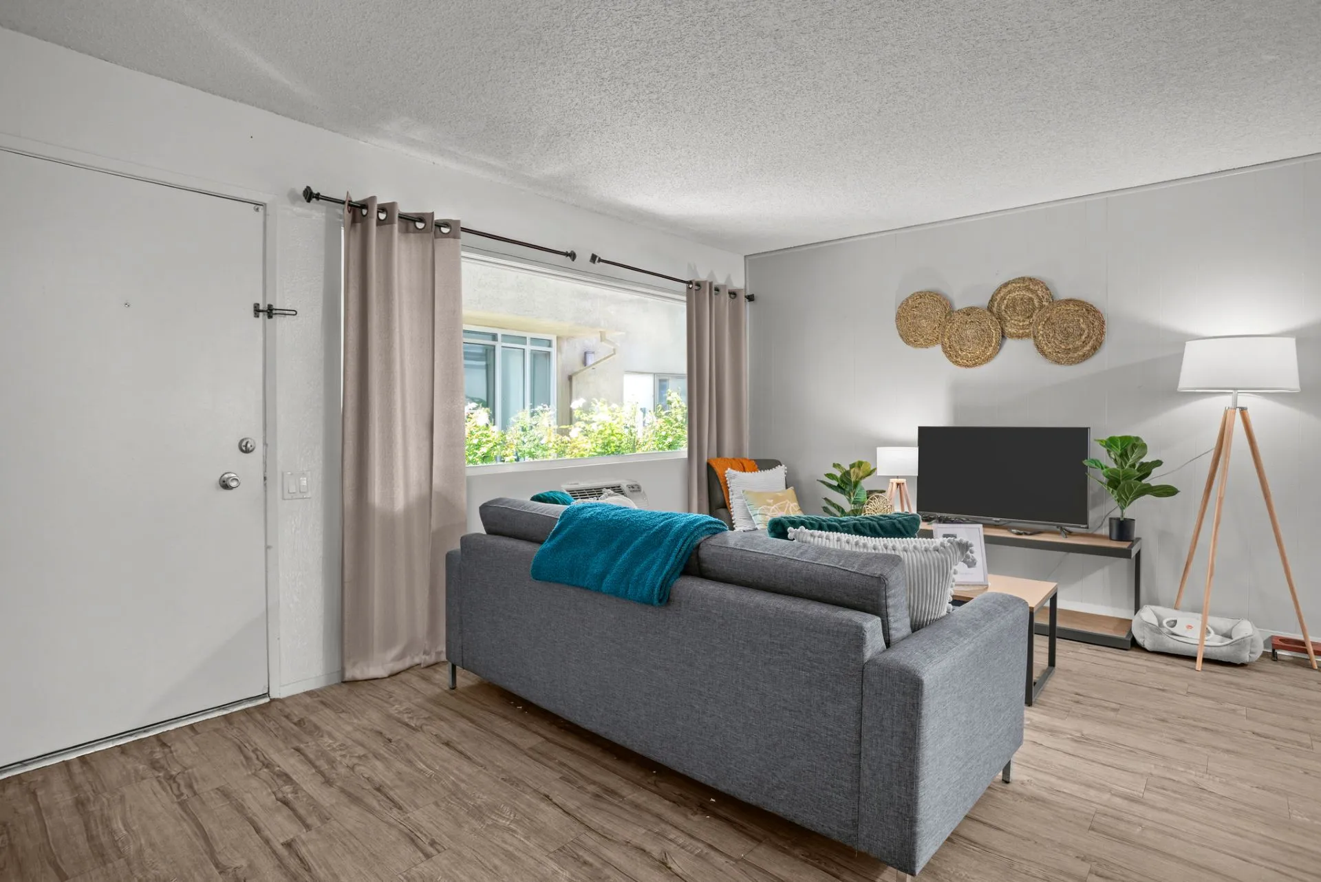 living area with sofa coffee table, tv, and large window
