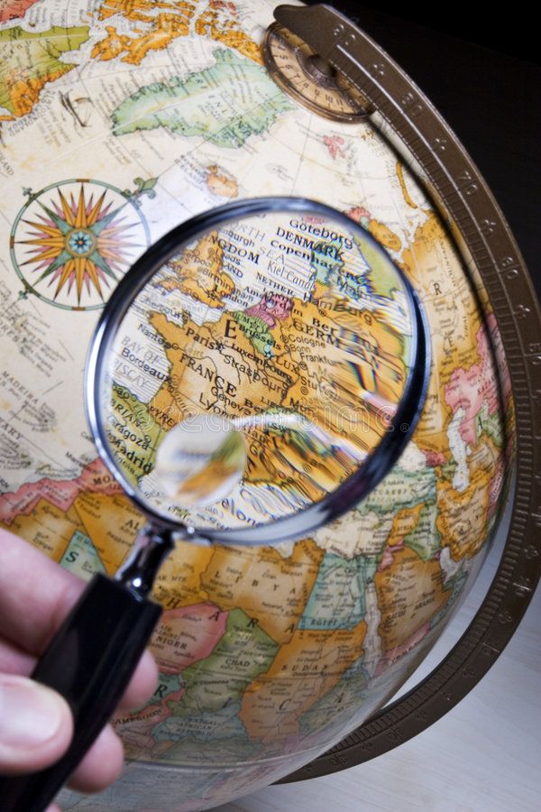 Magnifying glass over world map symbolizing choosing the right study abroad destination