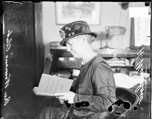 Mrs. William H. Winslow, Chicago Woman's Club president, sitting and reading book