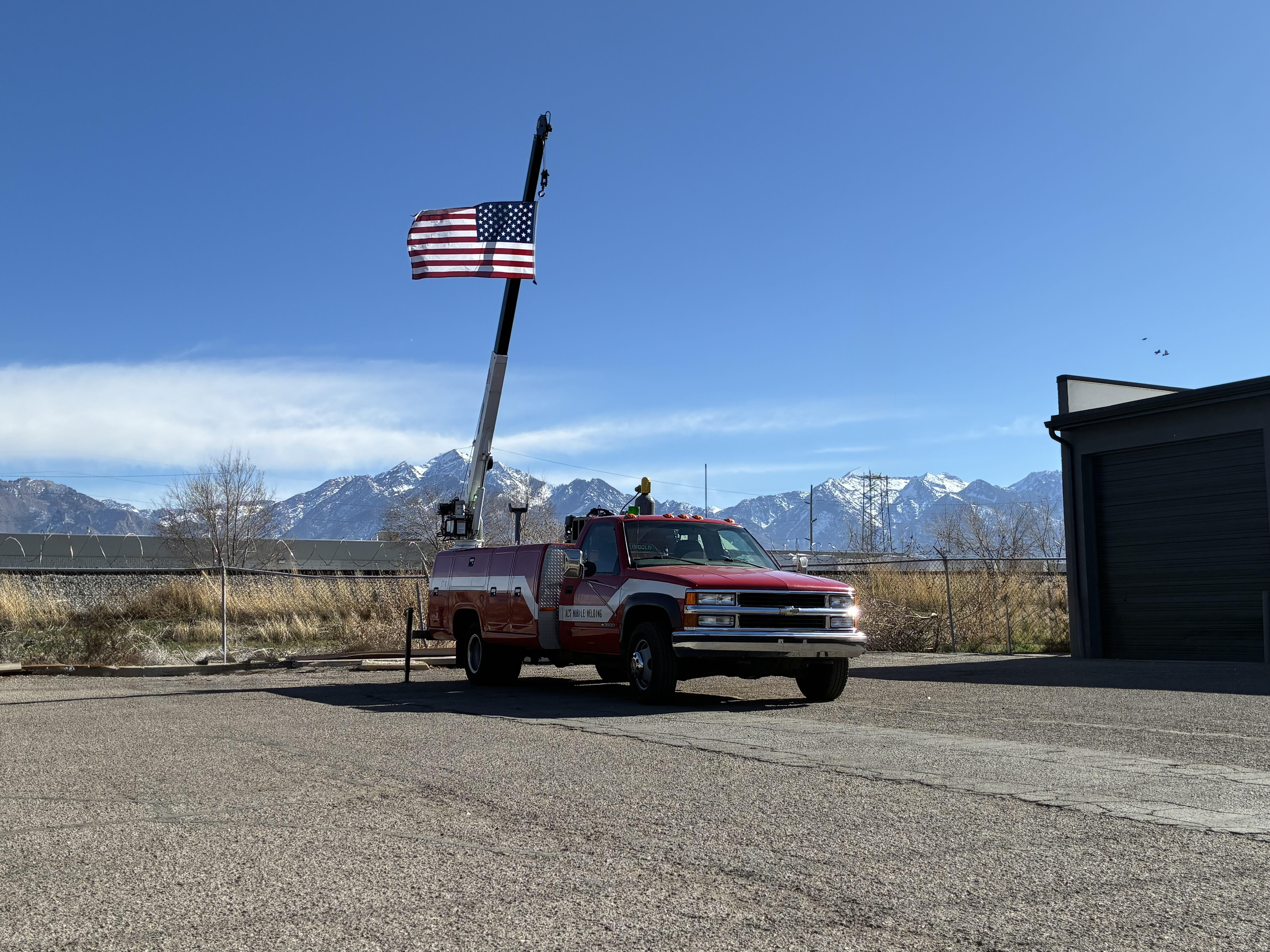Mackay Welding's Service Truck, Crane Raised Holding United States Flag