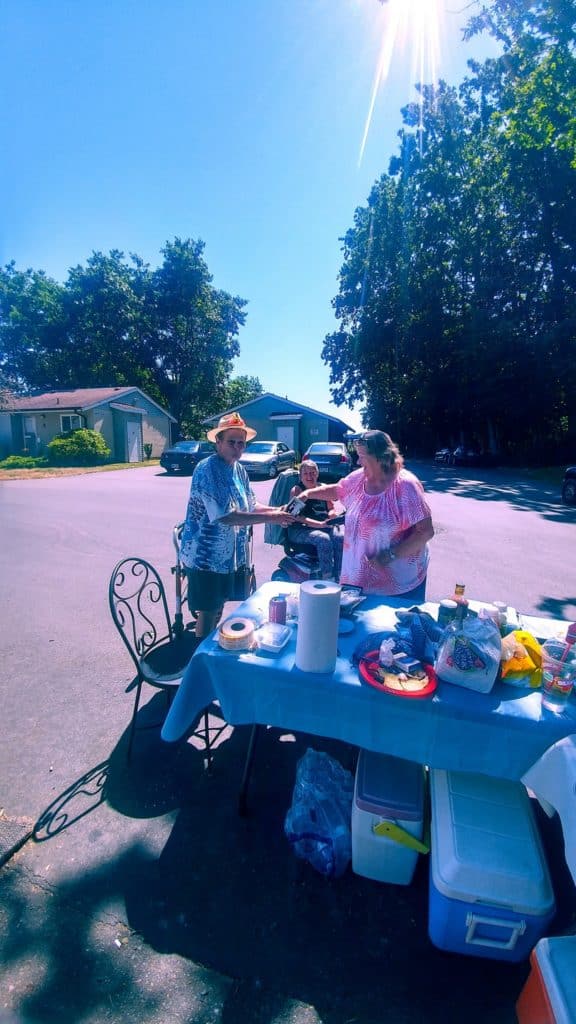 Older adults at hot-dog sale.