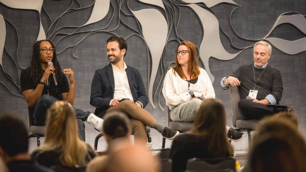 Four panelists seated on stage at a journalism conference with an abstract backdrop. LION Summit24