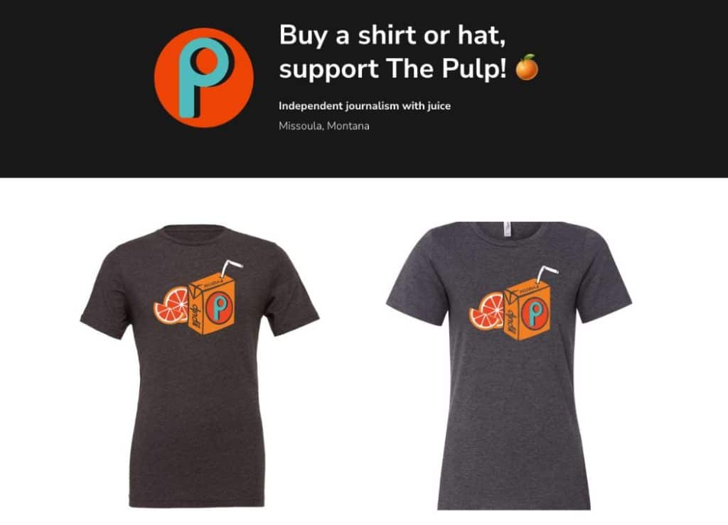 Promotional image for The Pulp featuring two dark gray T-shirts with a cartoon juice box design that includes an orange slice and a straw. The top of the image reads “Buy a shirt or hat, support The Pulp! 🍊 Independent journalism with juice – Missoula, Montana.”
