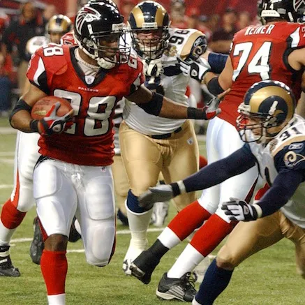 Atlanta Falcons football player running with the ball while being pursued by St. Louis Rams defenders during a game.
