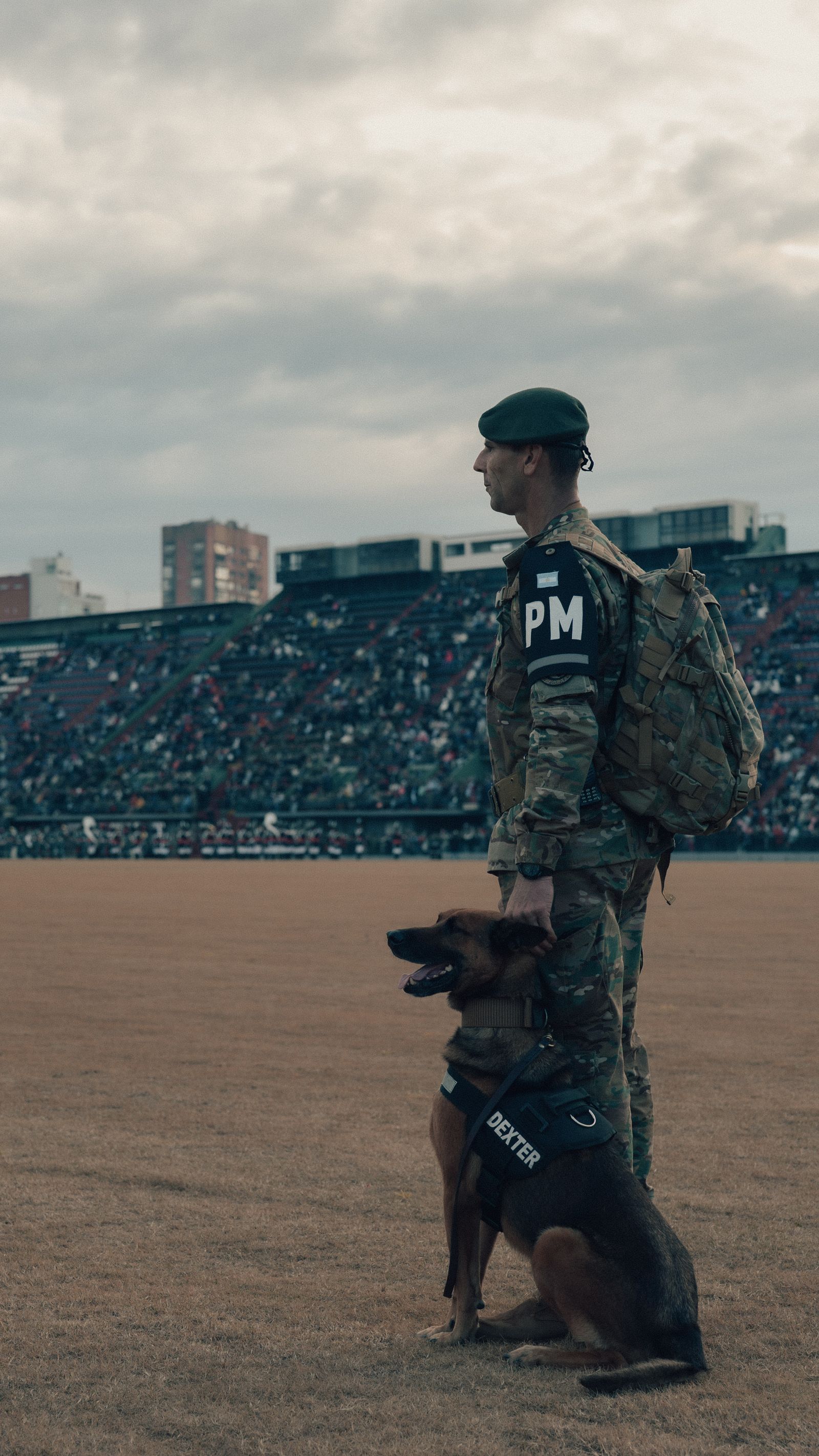 Handler standing with a detection dog during a stadium sweep.