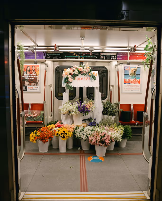 Flower shop stand with colorful flowers inside a subway train carriage.