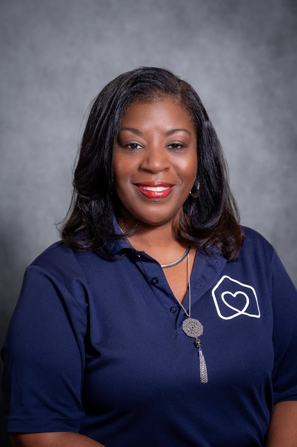 Shelly Thomas smiling in navy school staff polo shirt