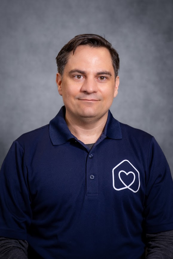 Stephen Armada staff headshot in navy polo shirt