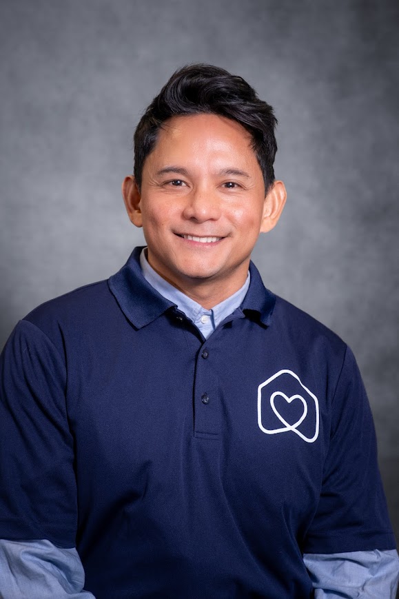 Franz Loza smiling in a navy Hearts Teams polo shirt