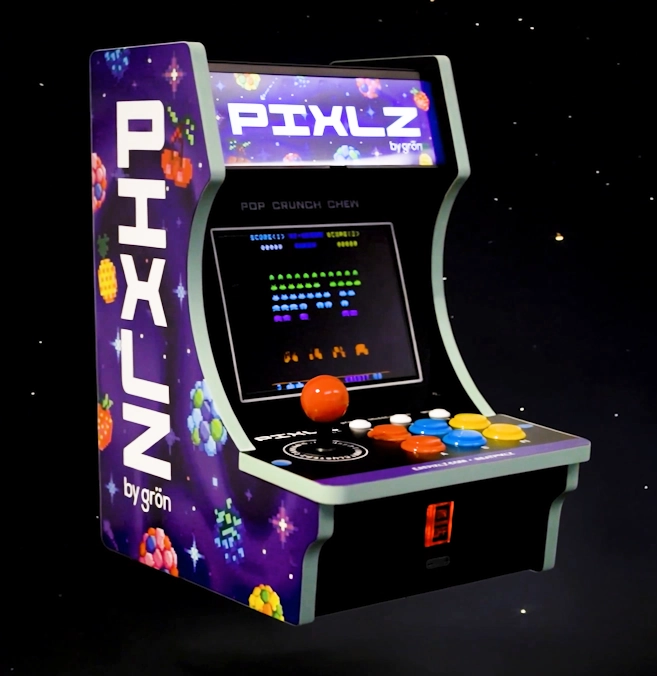 Retro-style arcade console with joystick and colorful buttons displaying the game PIXLZ.