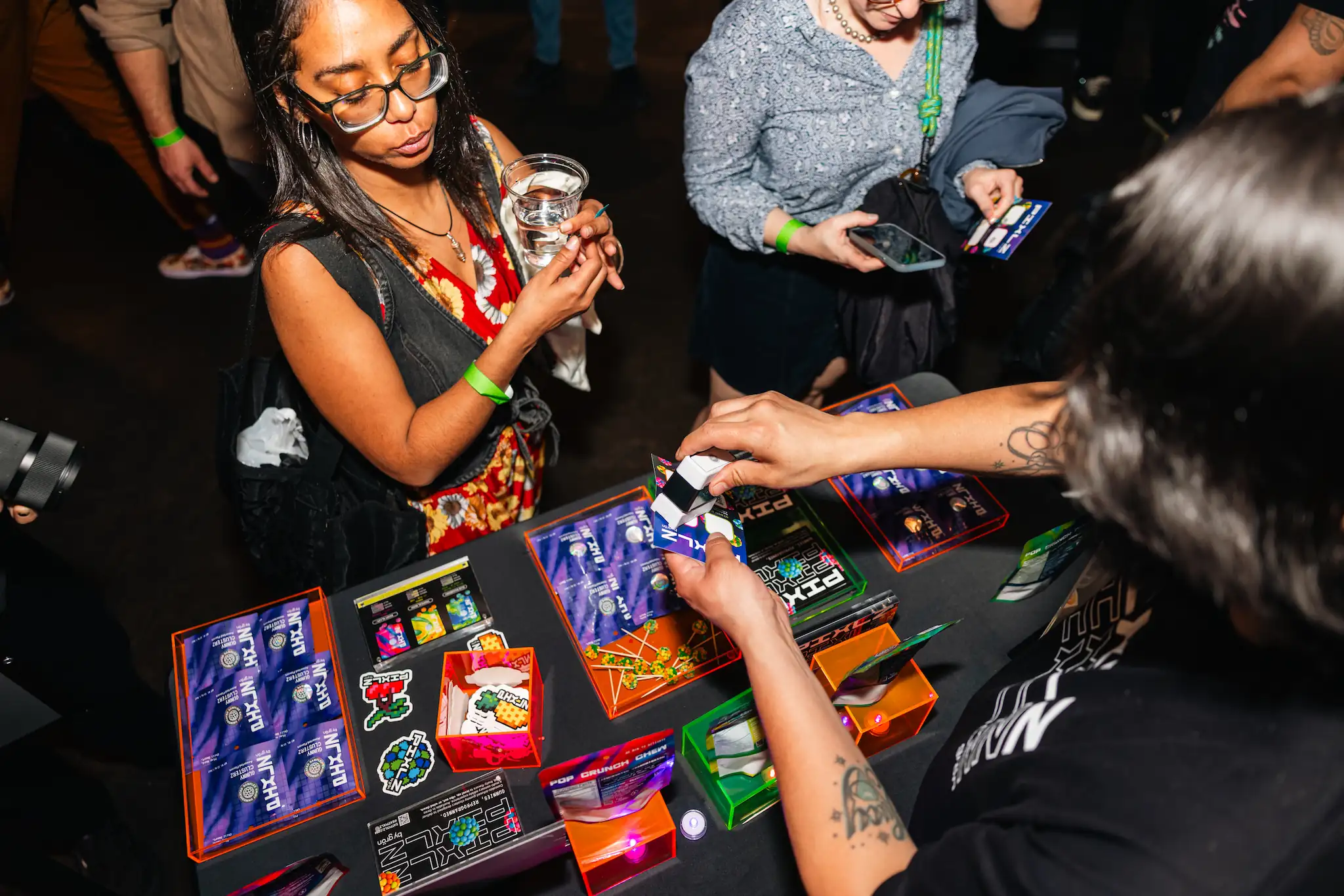 People interacting at a table with colorful product packaging and lottery-style scratch cards.
